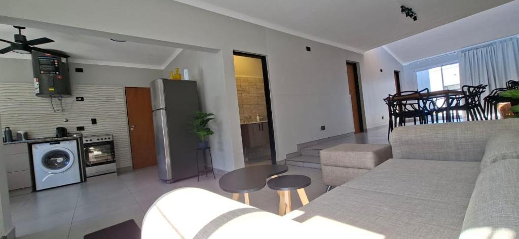 a living room with a couch and a table and a kitchen at Casa Prado in San Fernando del Valle de Catamarca