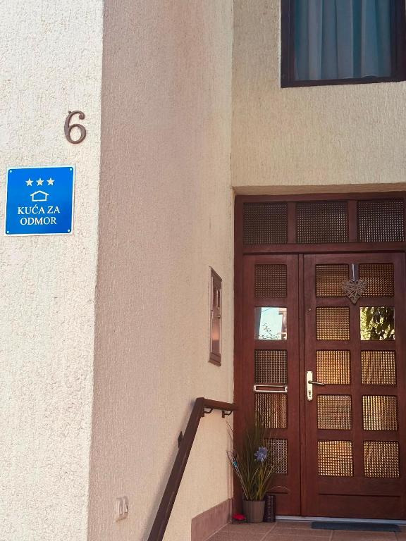 a building with a door and a sign on it at Kuća za odmor MEDUNIĆ in Gospić