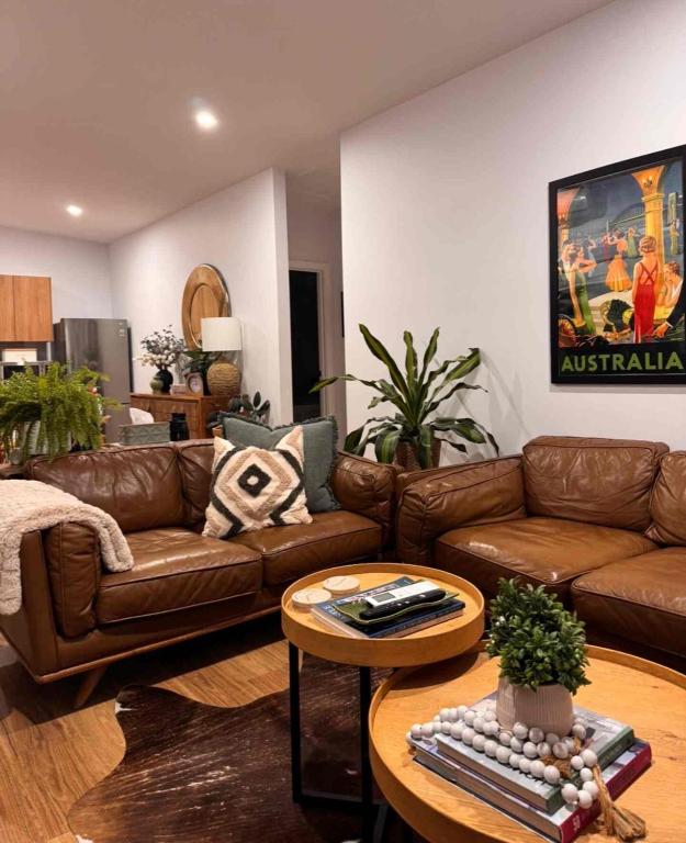 a living room with a brown couch and a table at Guest favourite Ocean Views Breakfast Included in Charlestown
