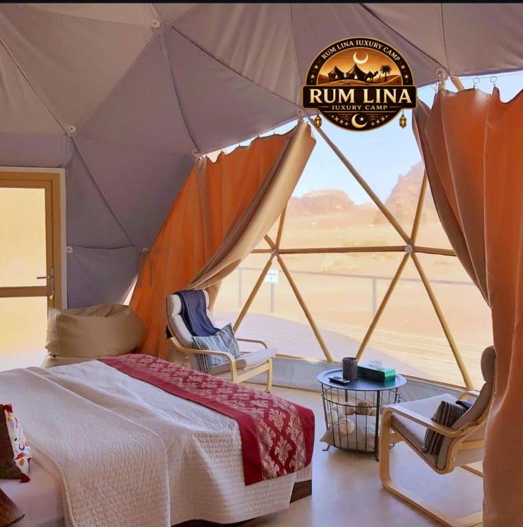 a bedroom with a tent with a bed and chairs at RUM LlNA lUXRY CAMP in Wadi Rum