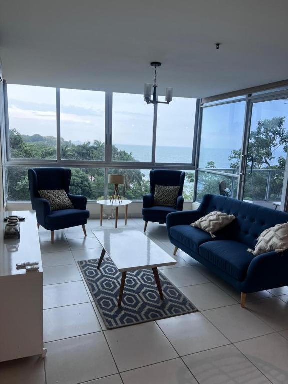 a living room with couches and a table and windows at Beach apartment on the seashore in Las Lajas