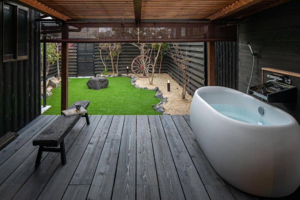 a bathroom with a bath tub on a wooden deck at 宿すごろく-Sugoroku Inn- in Nagahama