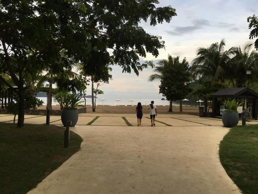 two people walking down a path in a park at 1BR Condo Unit in Pico De Loro in Nasugbu