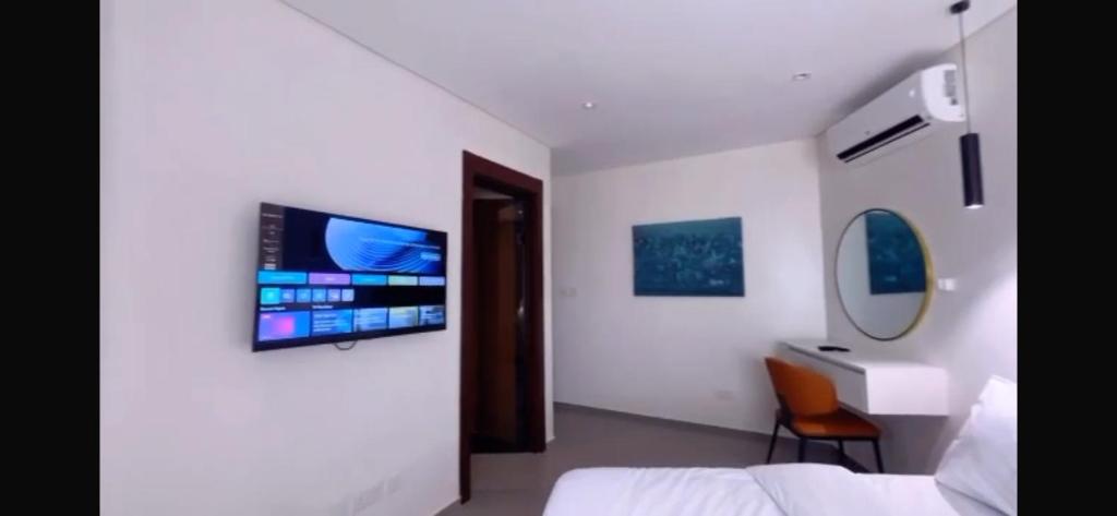 a hospital room with a bed and a tv on a wall at Orange Place - Benson Close in Lagos
