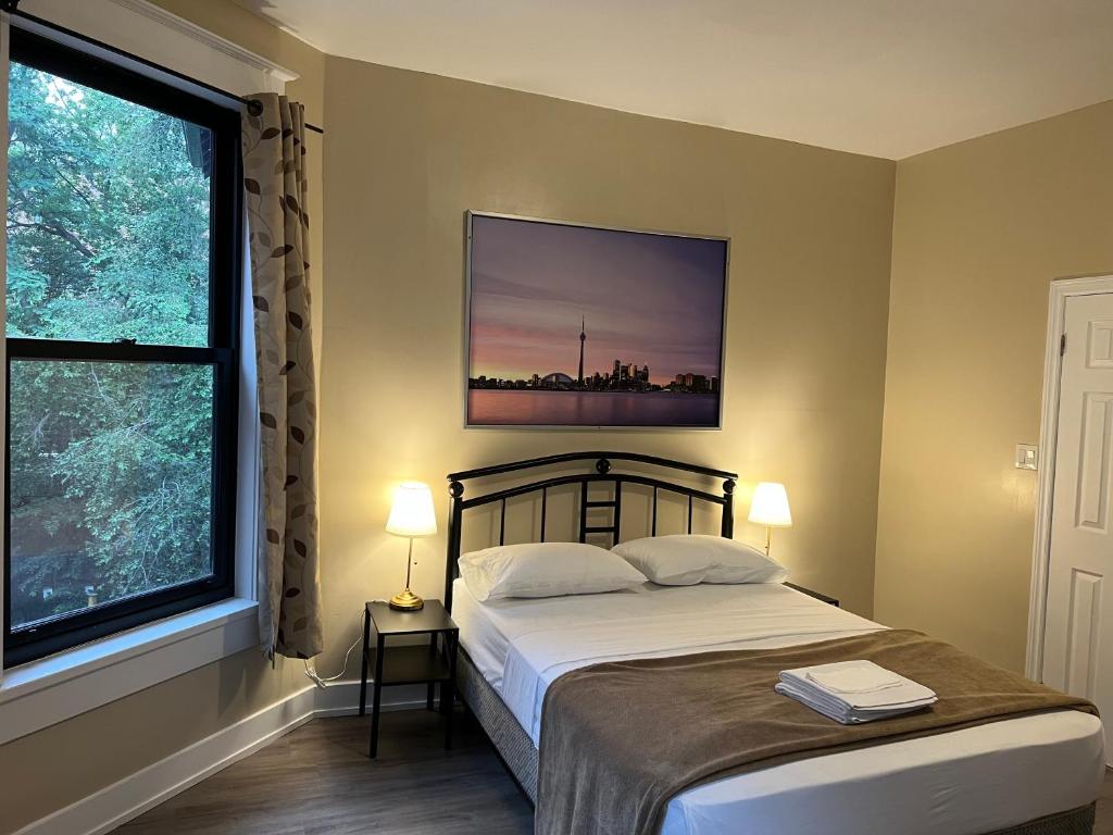 a bedroom with a bed and a large window at Bauer Guesthouse in Toronto