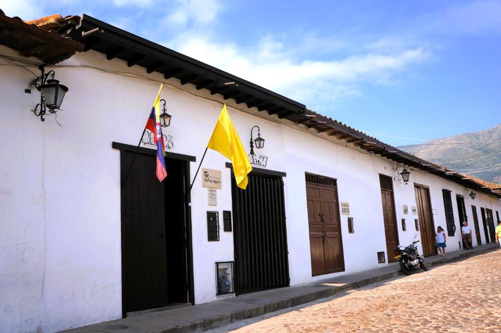 a building with two flags on the side of it at Hotel Boutique Macaregua Girón in Girón