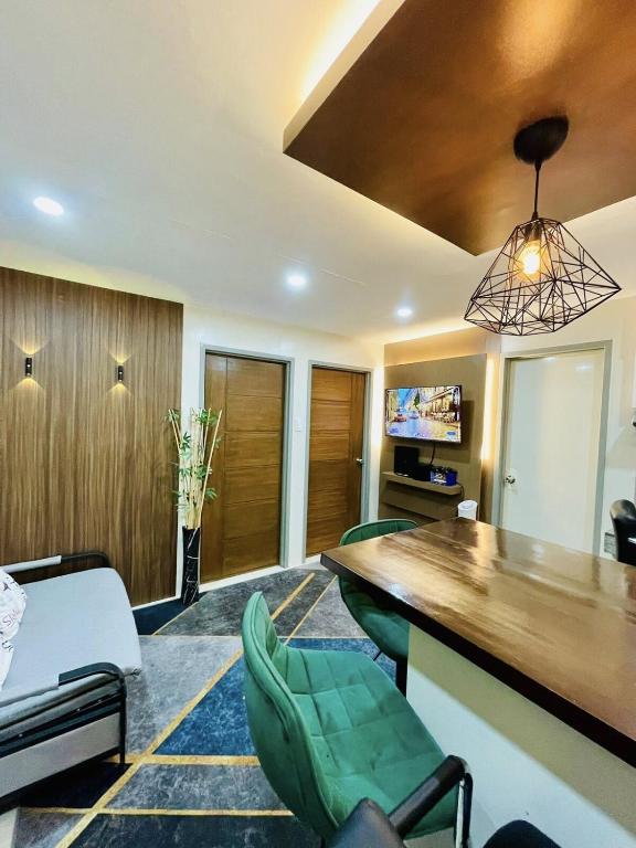 a living room with a bar and green chairs at 2BR Condo with pool at Sorrento Oasis Pasig in Manila