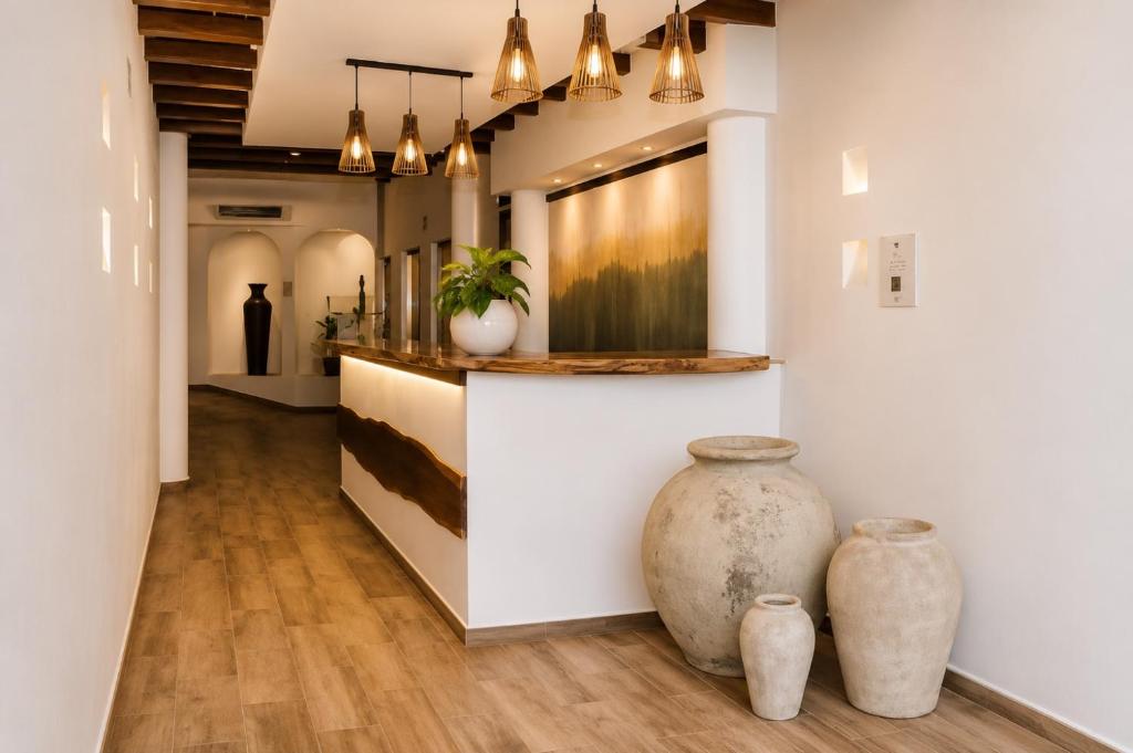 a lobby with a counter and two vases on the floor at Magico s apartments in Playa del Carmen