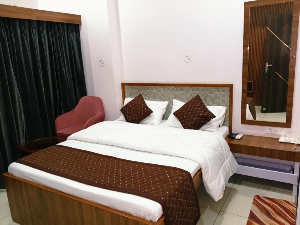 a bedroom with a large bed and a mirror at Aditya Residency, Bhagalpur in Barāri