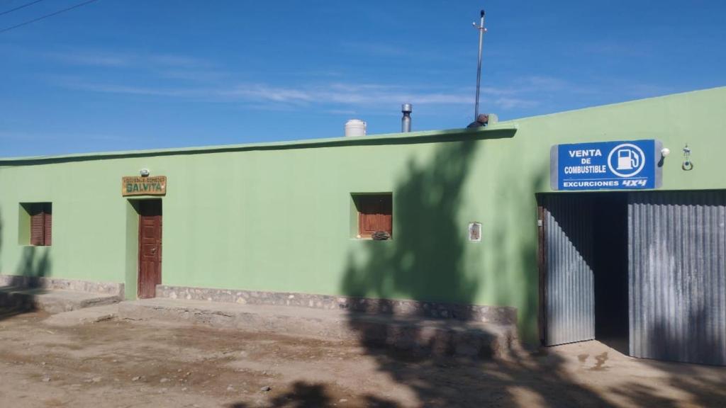 a green and white building with a sign on it at Salvita Hospedaje y Excursiones in El Peñón
