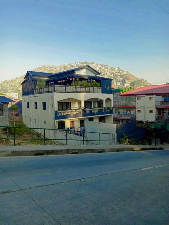 a building on the side of a street with a mountain at 2 Bedrooms with free parking in Baguio