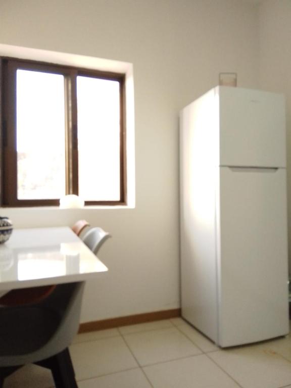 a white refrigerator in a room with a window at Casa de Cima in Doze Ribeiras