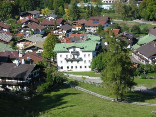 an aerial view of a large white house in a village at Hotel Garni Post in Grainau