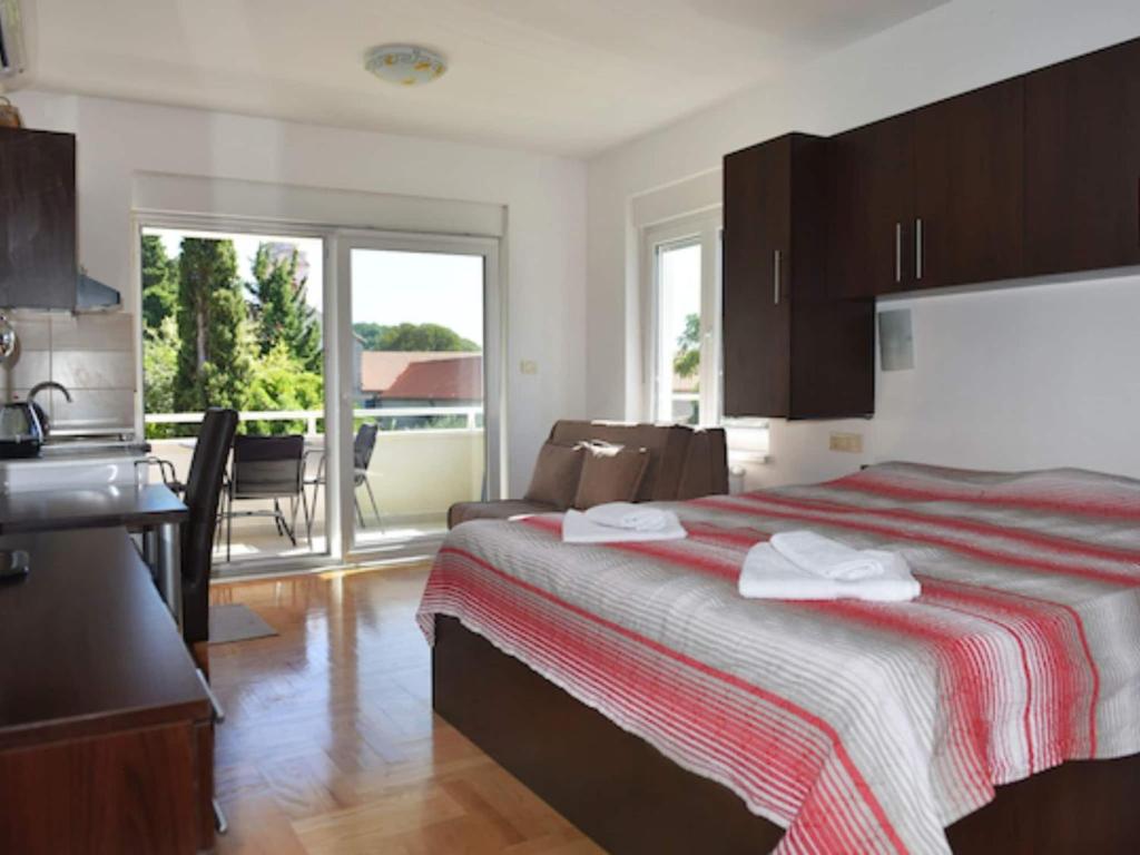 a bedroom with a bed and a kitchen with a balcony at Apartments Despot Zaostrog RL in Zaostrog