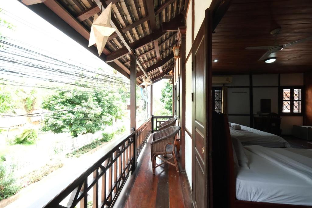 a room with a balcony with two beds on it at KhounPhet Hotel in Luang Prabang