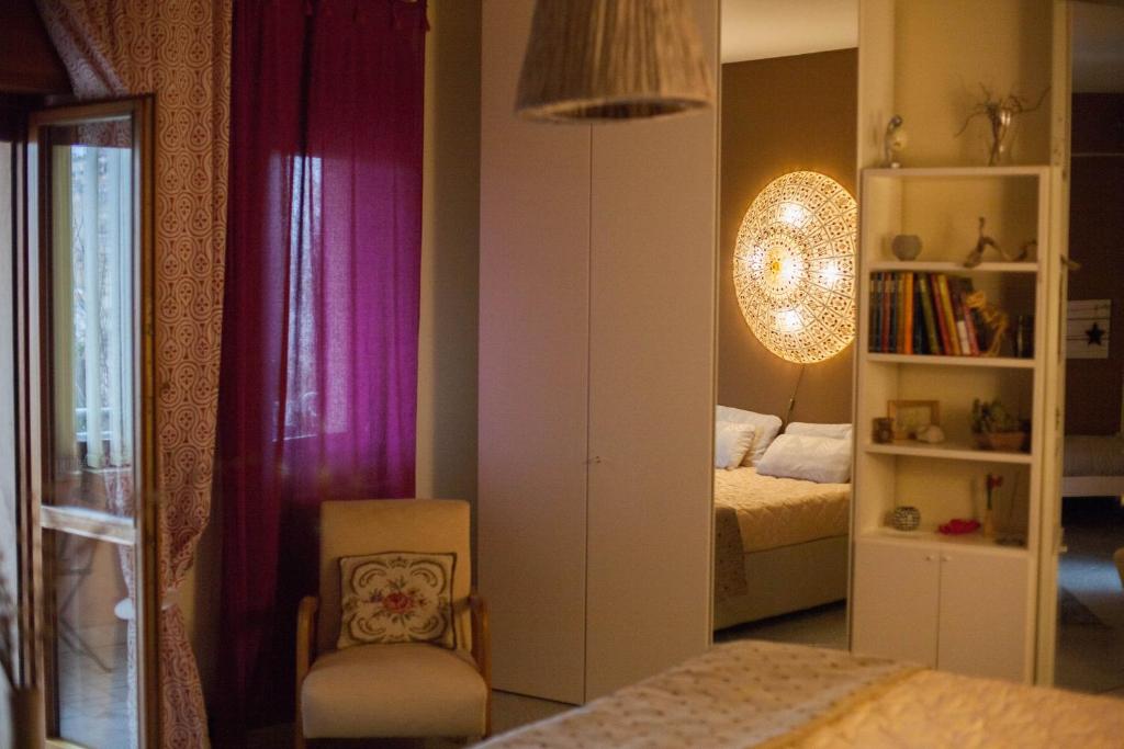 a bedroom with a bed and a chair and a mirror at Notti di luna in Potenza