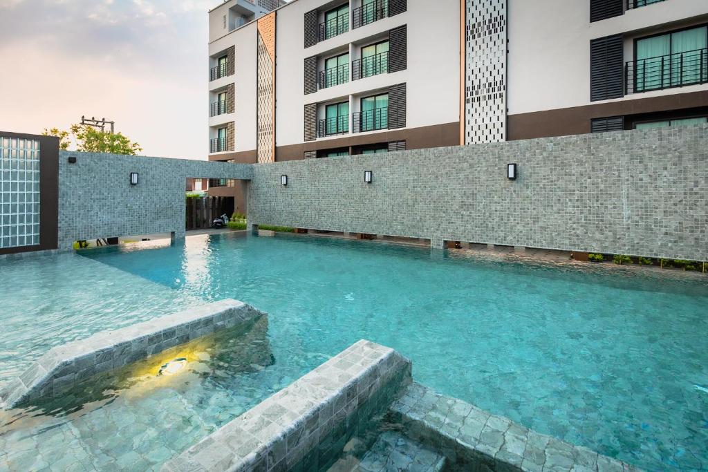 a swimming pool in front of a building at Wangkaew Hotel, Phitsanulok in Phitsanulok