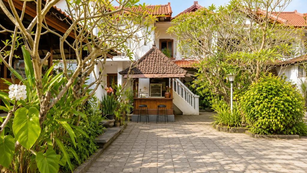 a courtyard of a house with a gazebo at Nakula Familiar Inn in Denpasar
