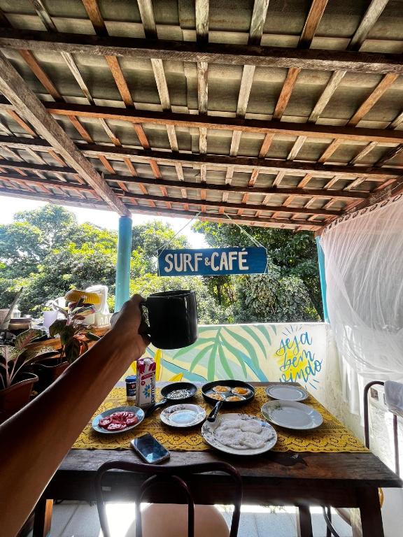 a person taking a picture of a table with food at Surf e Café in Cabo de Santo Agostinho