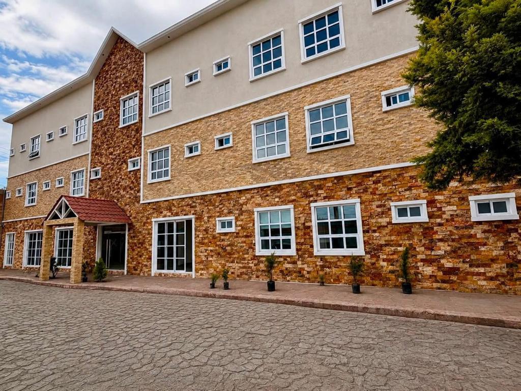 a large brick building with white windows on a street at Suite Casa Mia in Ciudad Sahagún