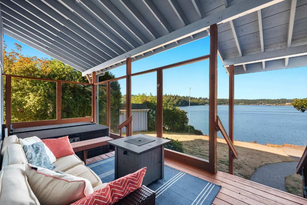 a screened in porch with a couch and a table at Phenomenal Sunsets Wild Orca & Private Beach in Shelton