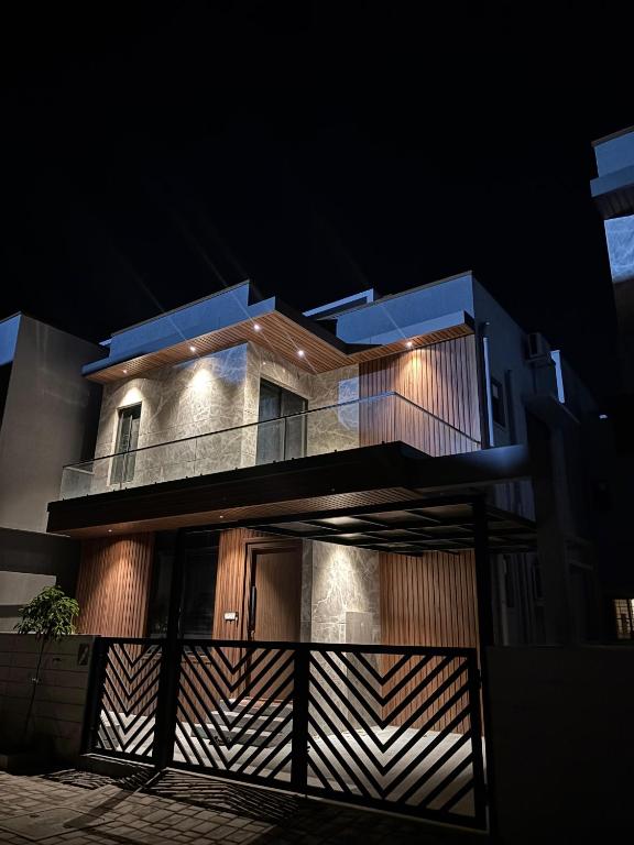 a building with a fence in front of it at night at Sara Luxe Stay ECR in Covelong