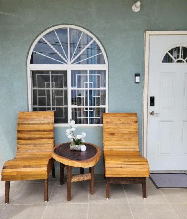 two chairs and a table in front of a door at Deluxe Estate in Portmore