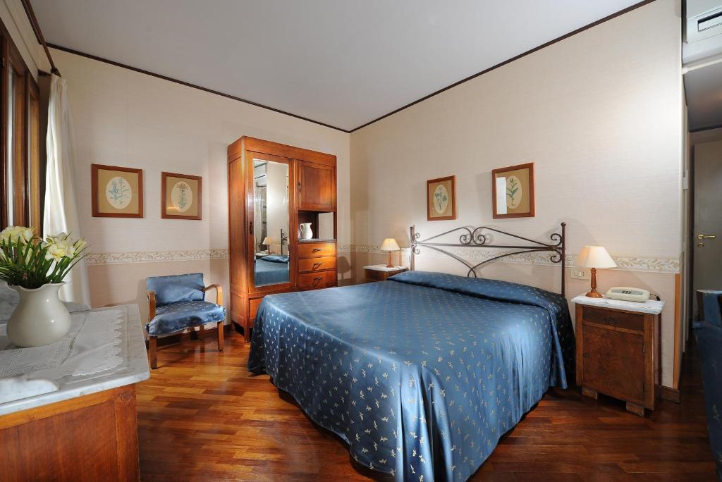 a bedroom with a bed with a blue bedspread at Hotel La Calcina in Venice