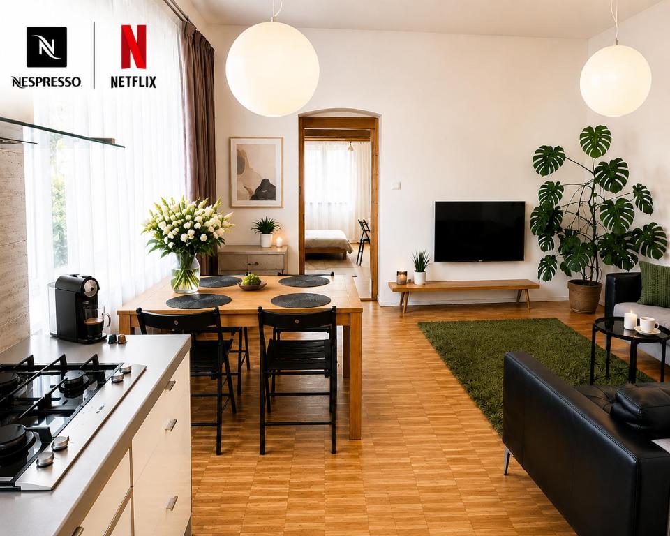 a kitchen and living room with a table and chairs at Like at home Brno - celý byt in Komárov