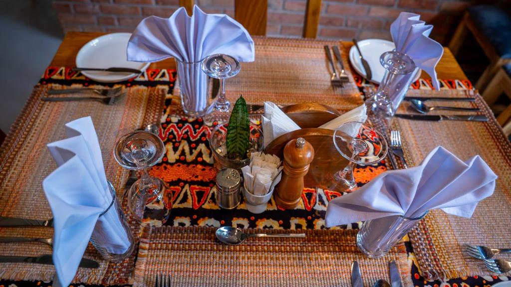a table with a table set with blue napkins and silverware at Maksoru Spring Lodge in Arusha