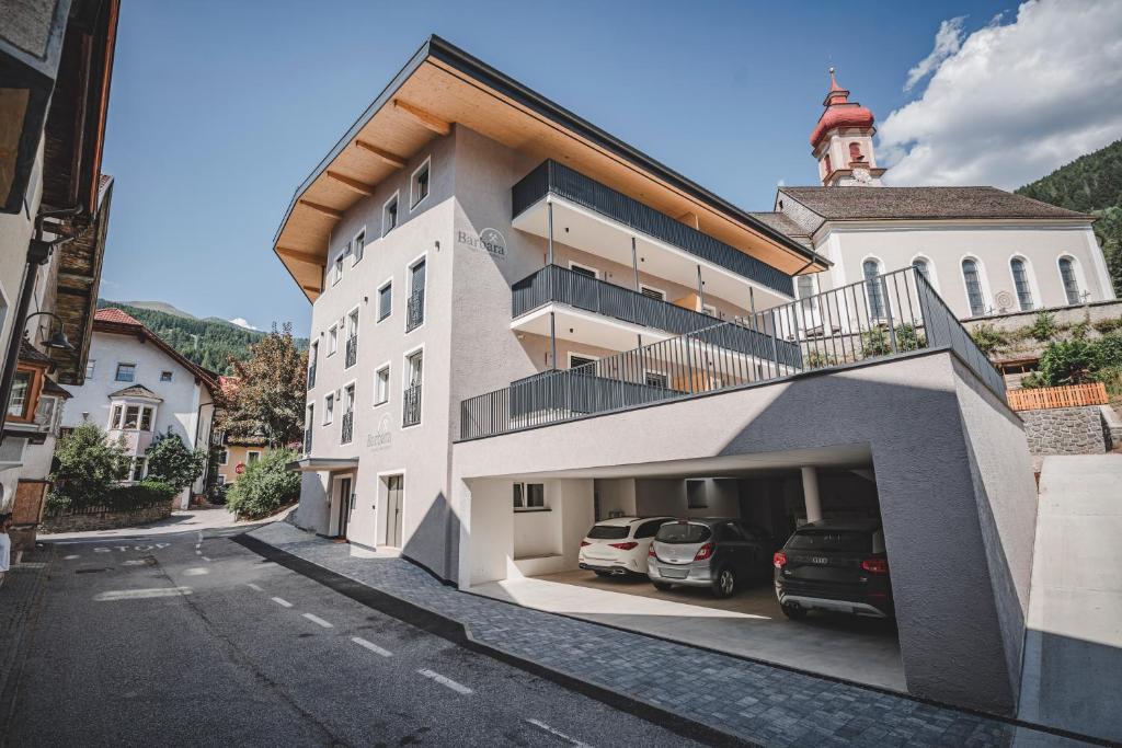 a building with cars parked in a parking lot at Historic Residence Barbara in Colle Isarco