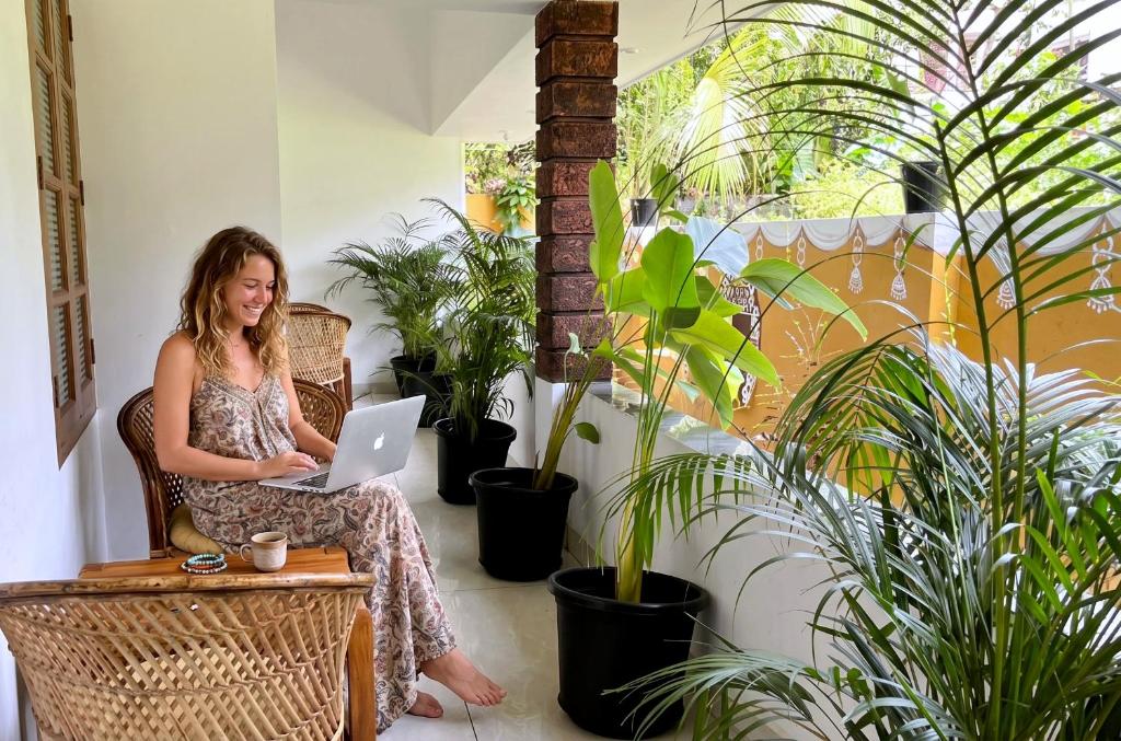 a woman sitting in a chair with a laptop at Gypsy Walker in Varkala