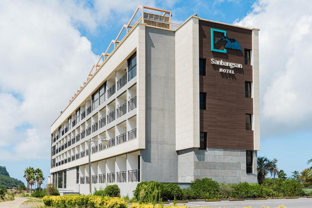 a building with a sign on the side of it at Sanbangsan Hotel in Seogwipo