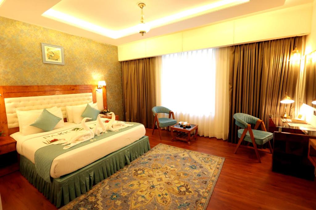 a hotel room with a bed and a desk at Park Ocean in Jaipur