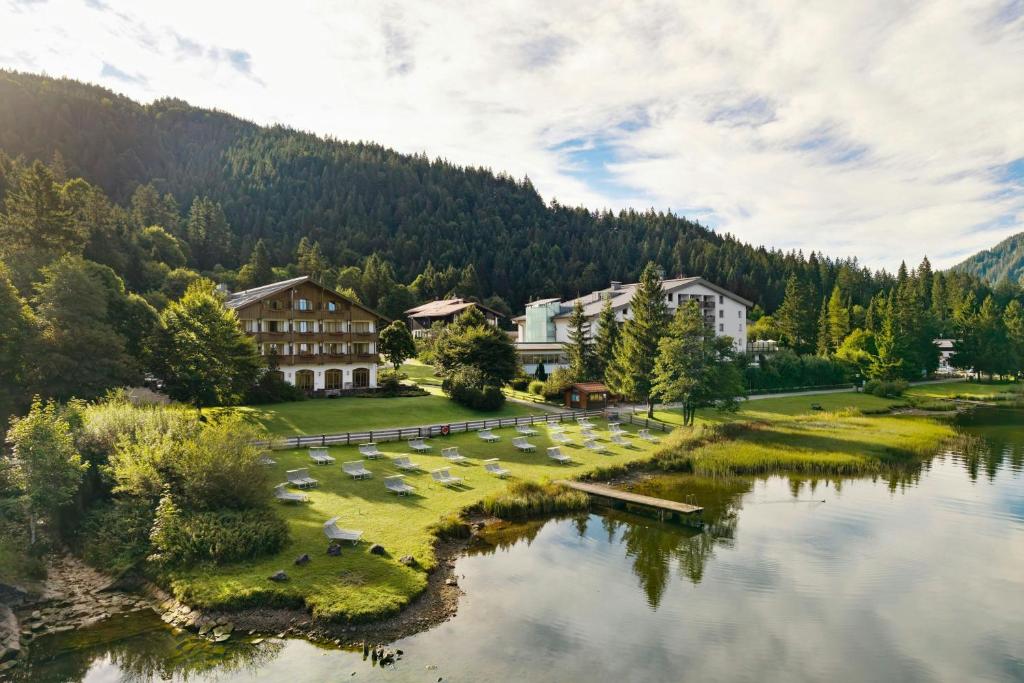 a group of buildings next to a body of water at Arabella Alpenhotel am Spitzingsee, a Tribute Portfolio Hotel in Spitzingsee
