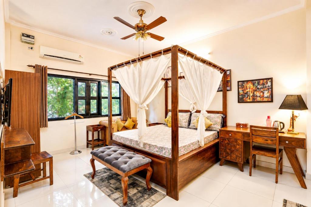a bedroom with a canopy bed and a desk at House Of Comfort Greater Noida in Greater Noida