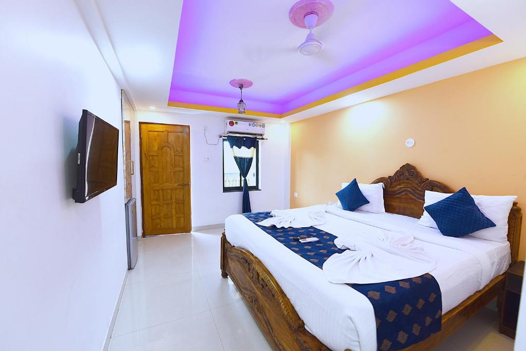a bedroom with a large bed with a purple ceiling at Veronica By The Beach Calangute in Calangute