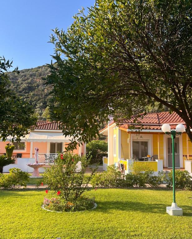 a yellow house with a tree in the yard at Elisabeth Villas in Kerveli