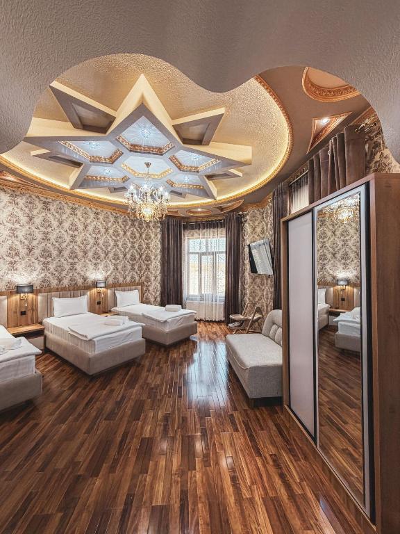 a living room with two beds and a ceiling at As-Mira Hotel in Samarkand
