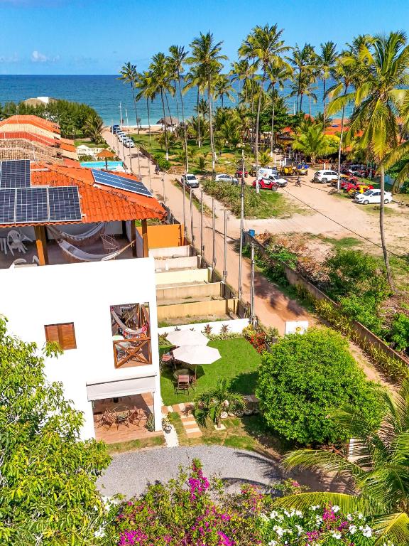 an aerial view of a street with palm trees and the ocean at Pousada Vila dos Santos in Porto De Galinhas