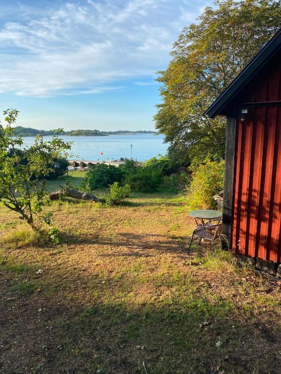 a picnic table next to a building with a view of the water at Havsutsikt in Ronneby