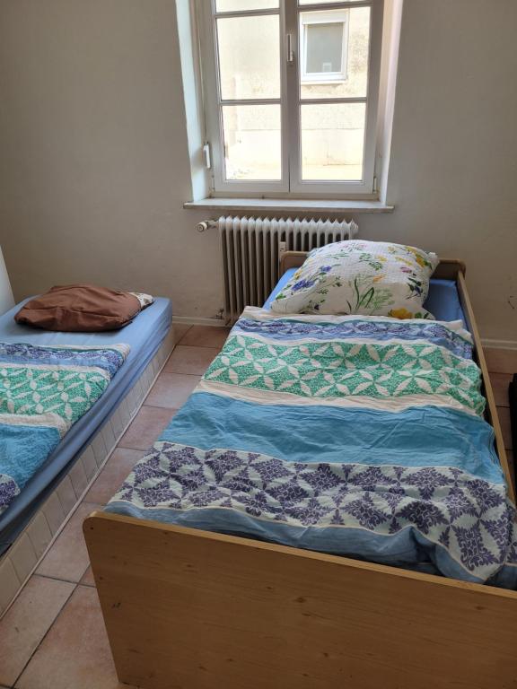 two twin beds in a room with a window at Simple Übernachtungsmöglichkeit in Krumbach