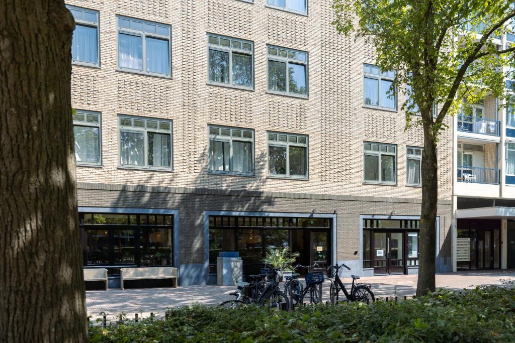 een bakstenen gebouw met fietsen ervoor geparkeerd bij Forest Hotel in Den Helder