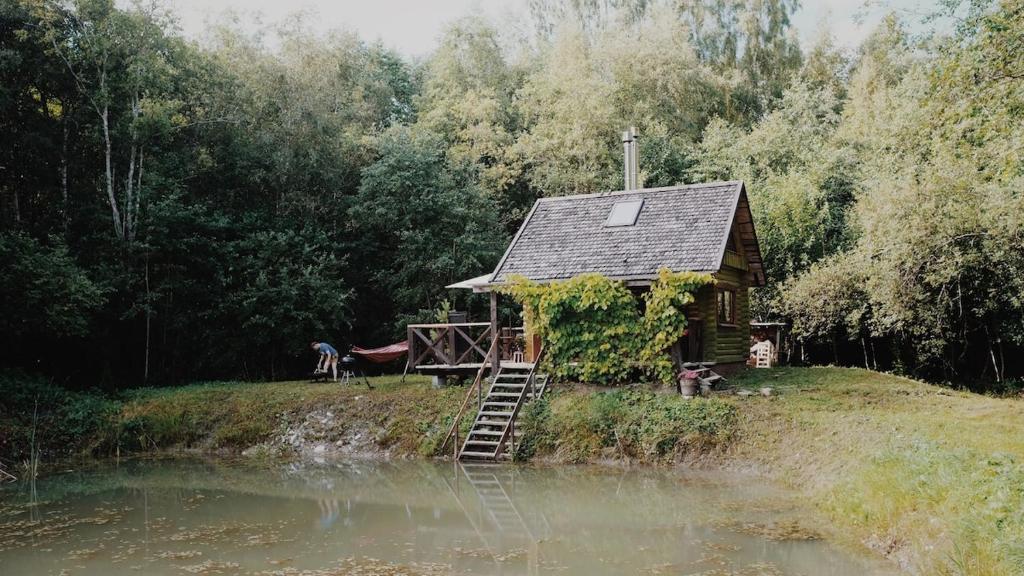 a small cabin on a hill next to a body of water at Härjamäe Saunamaja 