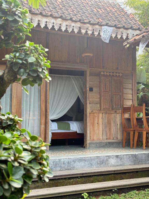a bedroom with a bed in a wooden house at Arta Wooden House in Sukawati