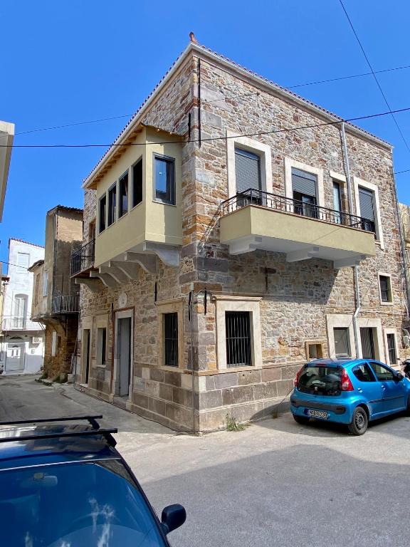 a blue car parked in front of a brick building at Encanto Griego in Chios