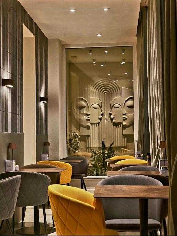 a restaurant with chairs and a wall with a mirror at Mirarti Boutique Hotel - Witamy in Rapallo