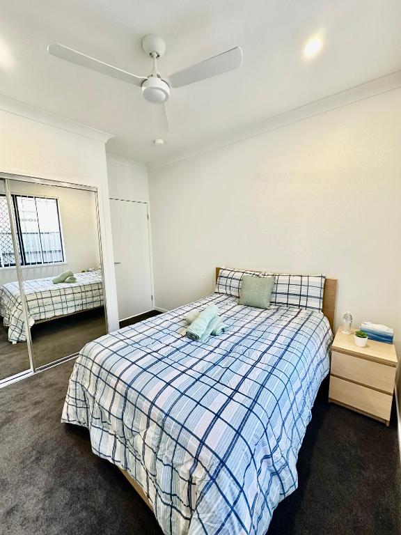 a bedroom with a bed and a ceiling fan at Stylish place in Loganlea in Loganlea