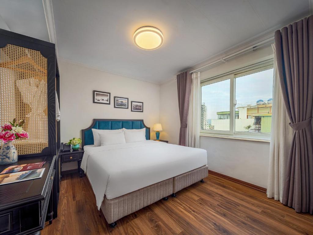 a bedroom with a large white bed and a window at Ritana Boutique Hotel & Spa in Hanoi
