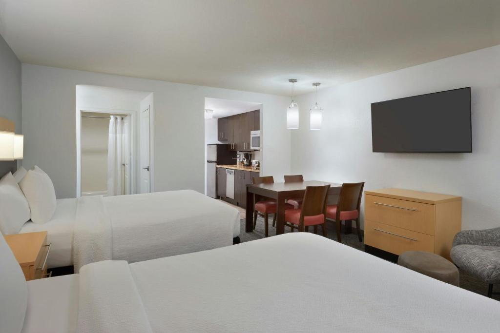 a hotel room with two beds and a table at TownePlace Suites by Marriott Thunder Bay in Thunder Bay